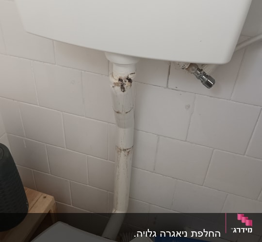 צינור מים לבן עם חלודה וחיבור ברז